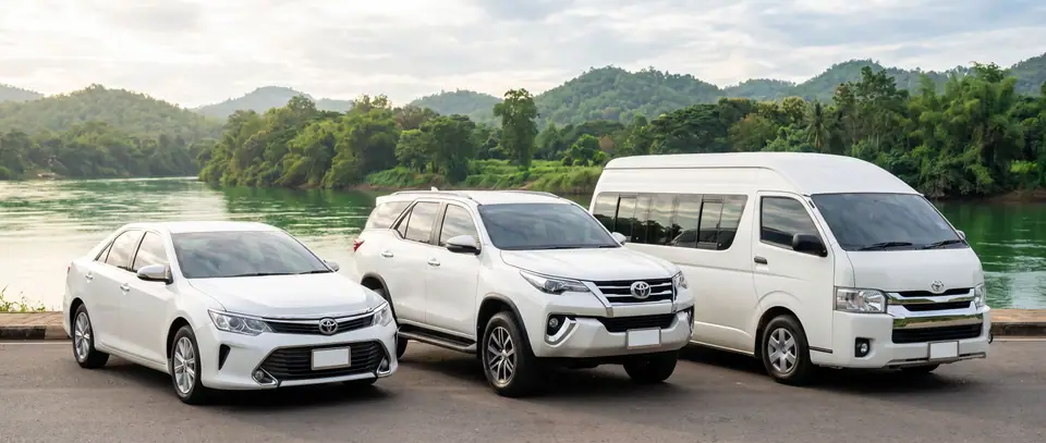 カンチャナブリの川辺に停まる白いセダン、SUV、バン